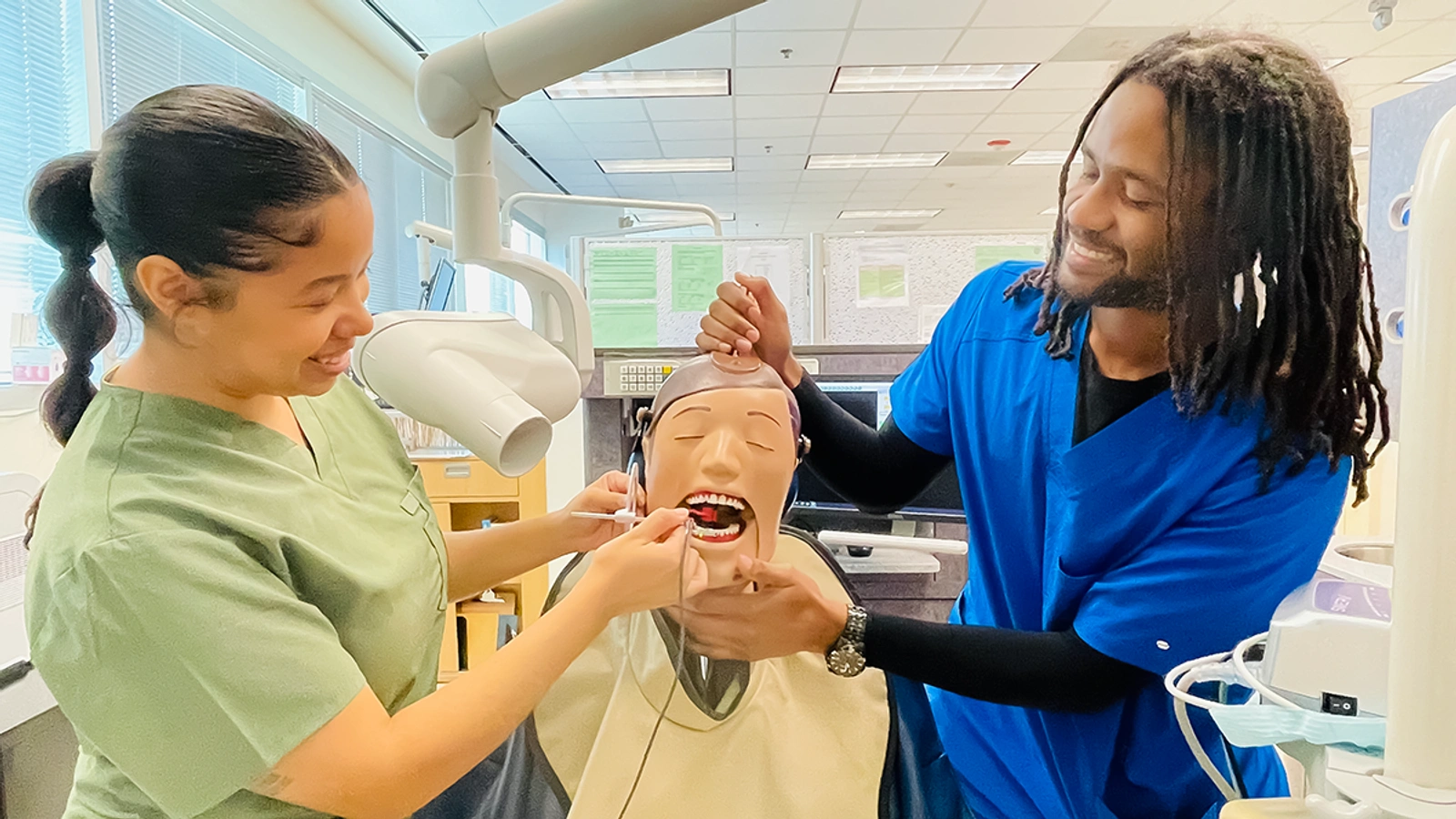 Two students practicing on how to exam the teeth