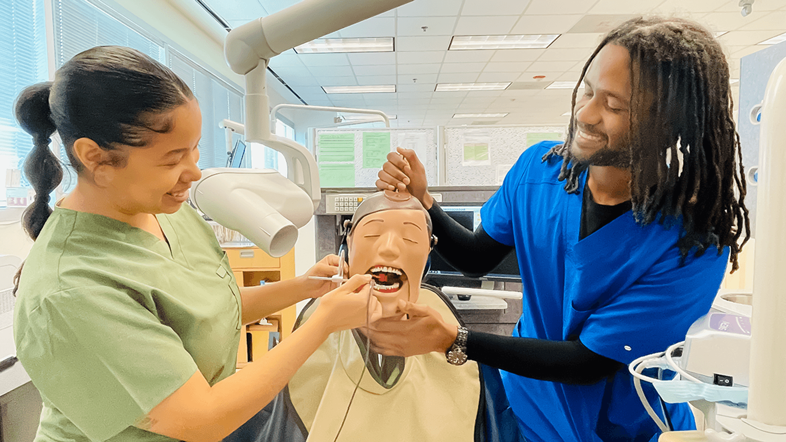 Two students practicing on how to exam the teeth