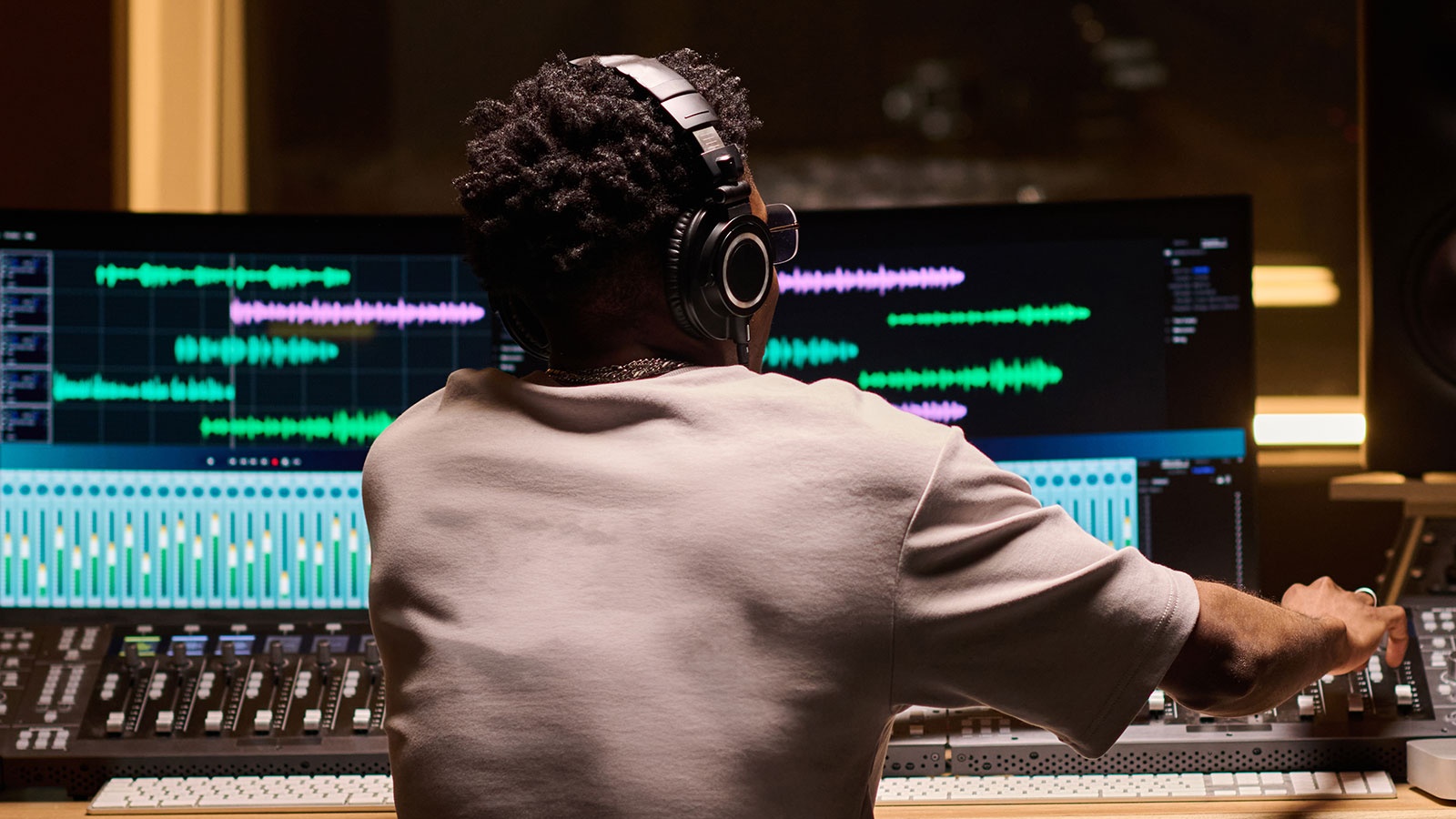 Audio engineer editing music at a mixing console