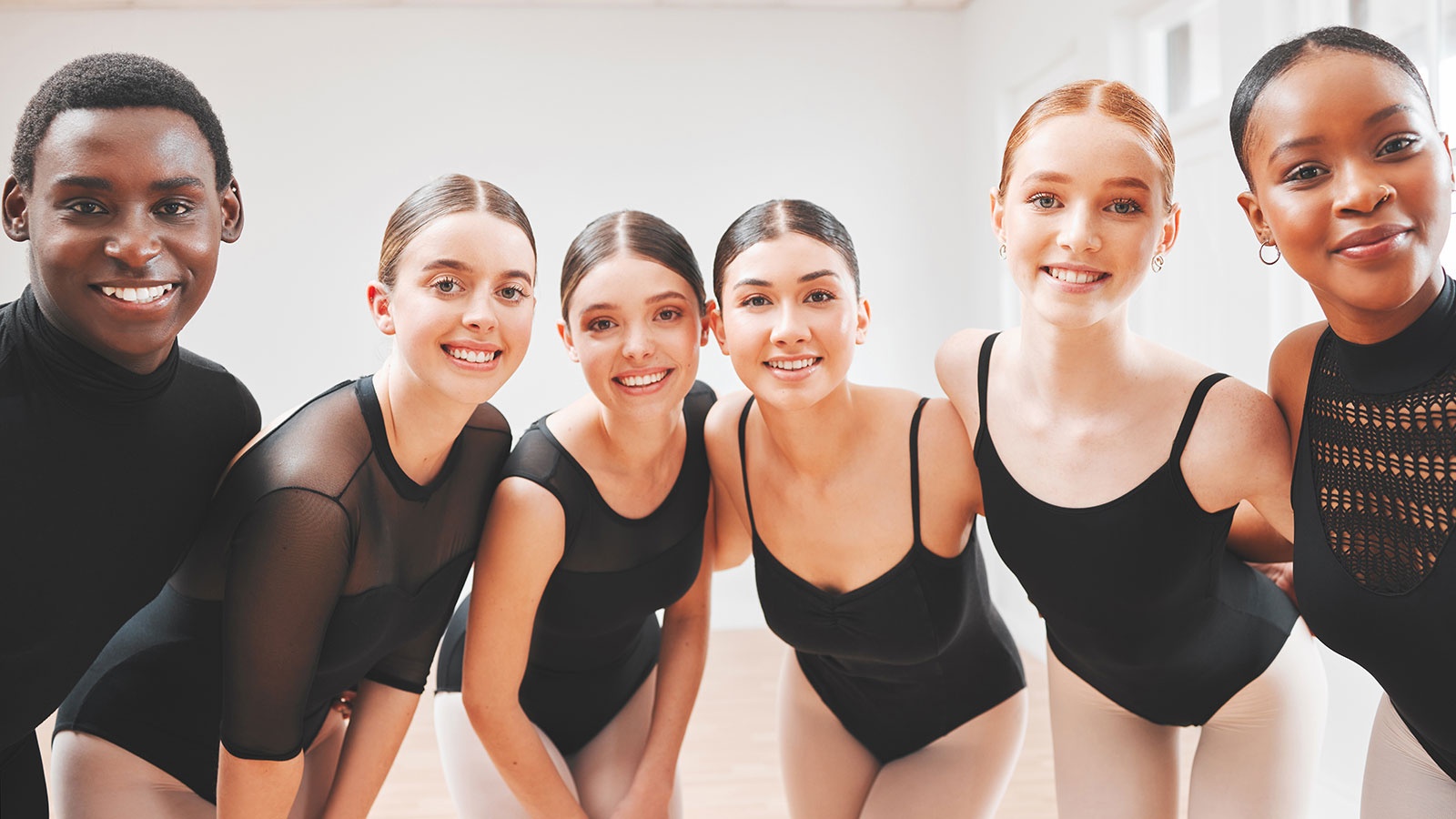 Five women and one male dressed in black dance attire.