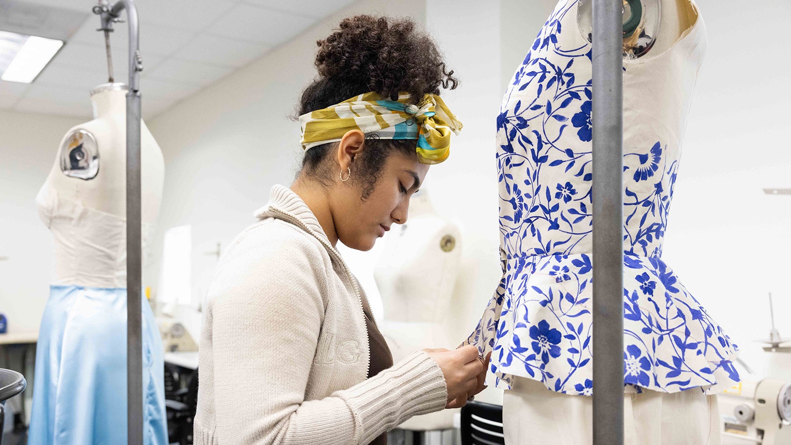 Female fashion student sewing a dress