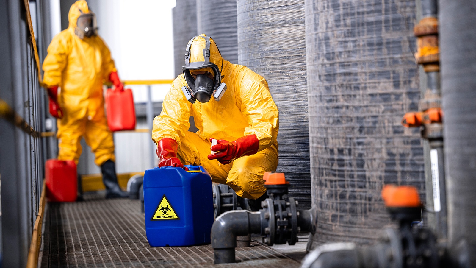 trained factory workers carefully handling toxic and dangerous biohazardous waste in chemicals factory