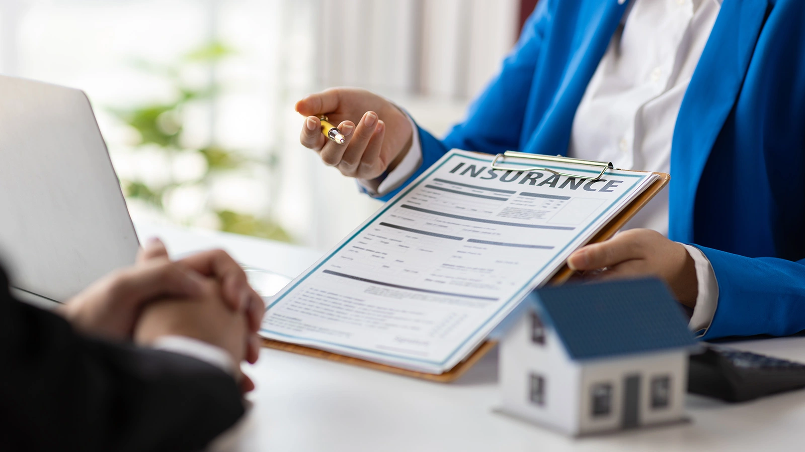 Insurance Agent explaining the terms of a home insurance contract document.