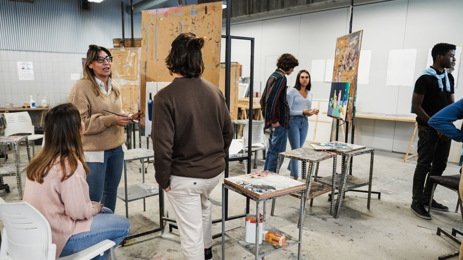 Students gather and talk in an art studio.