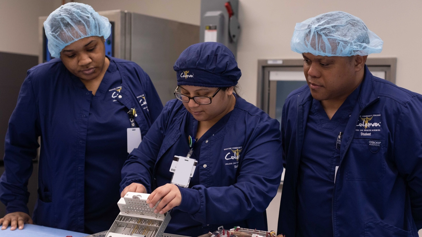 Three Sterile Processing program students work in the lab.