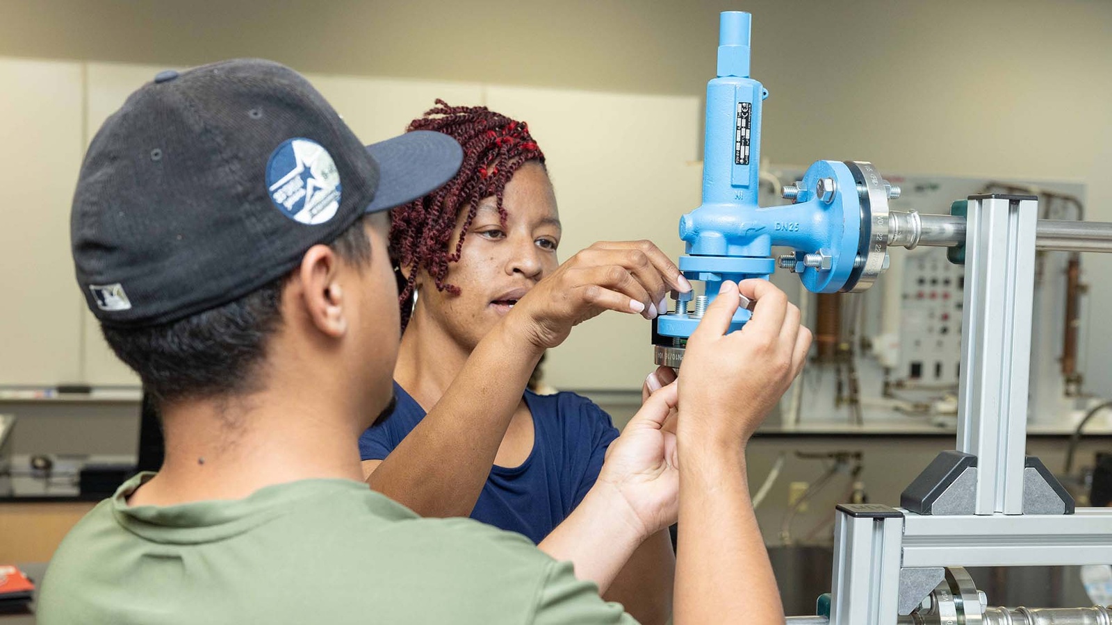 Process Technology students examining pipe fittings.