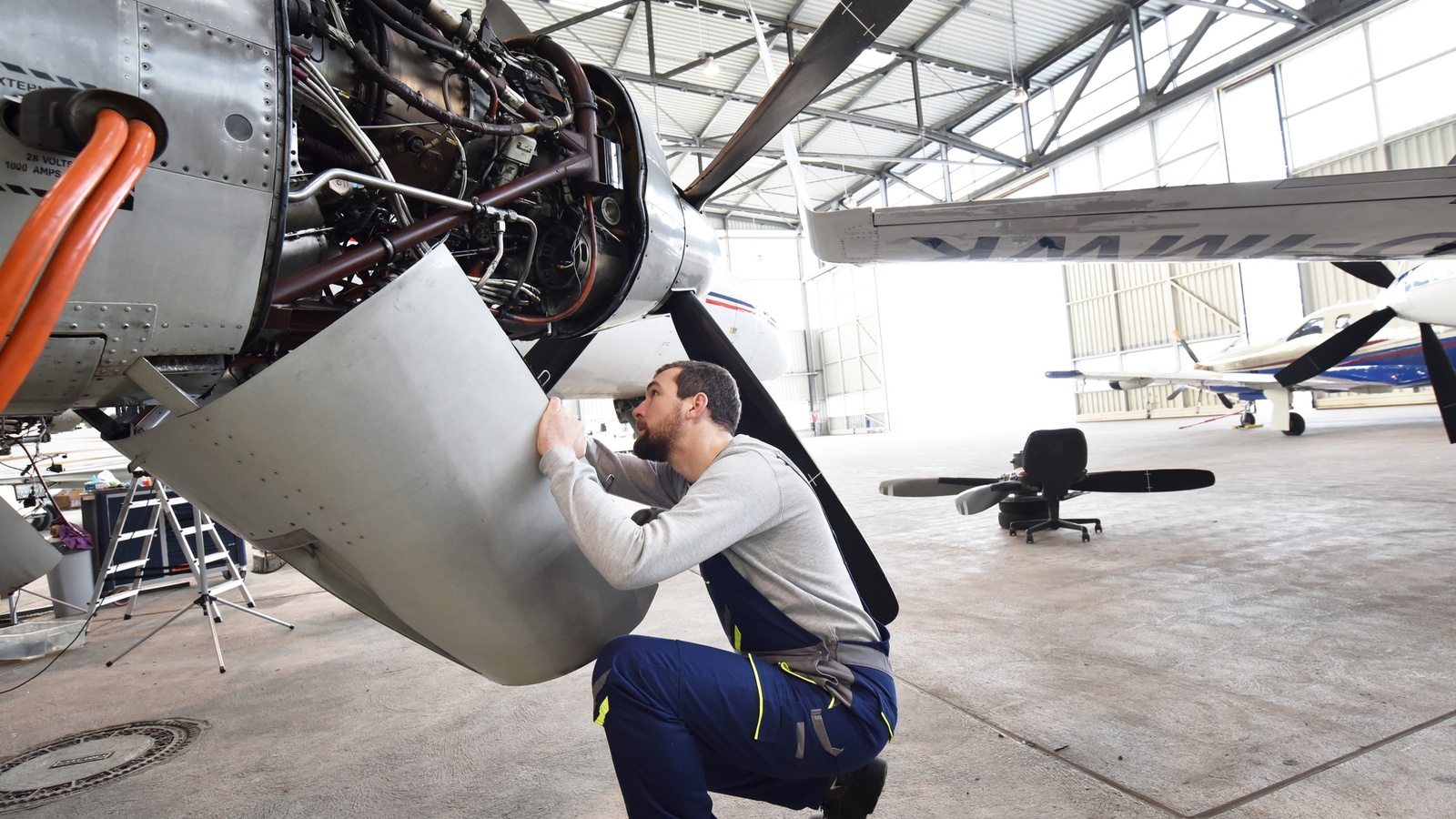 Airplane mechanic checking the engine of a plane