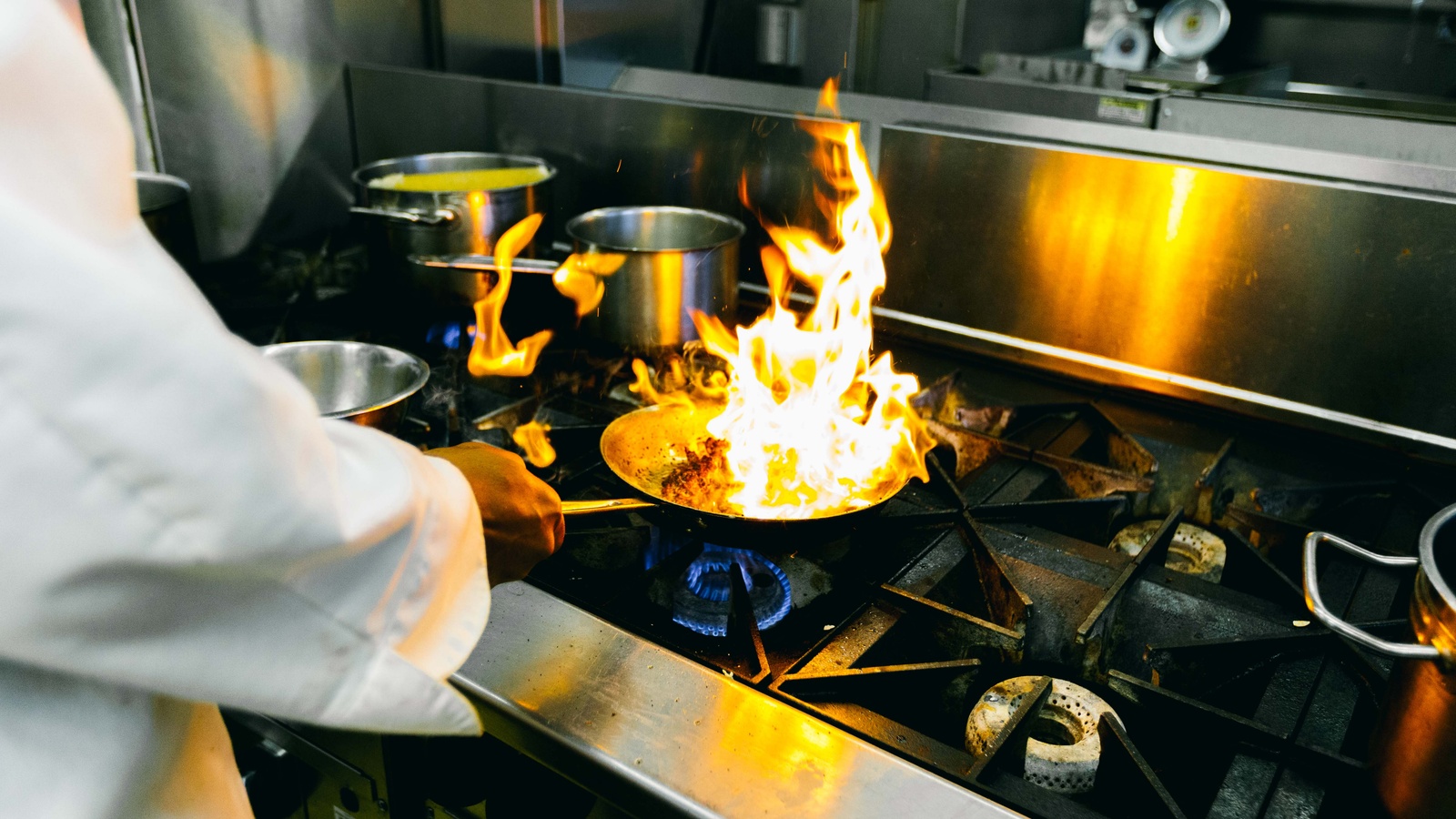 Culinary chef preparing a meal with a pan lit on fire