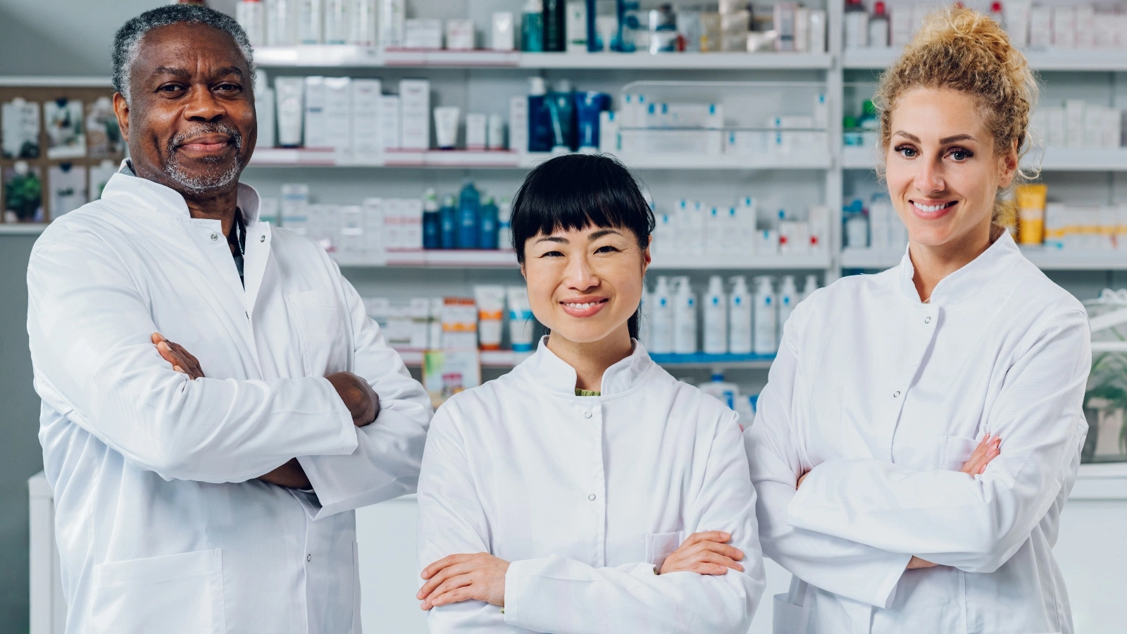 Pharmacy Technicians posing with medications in the background.