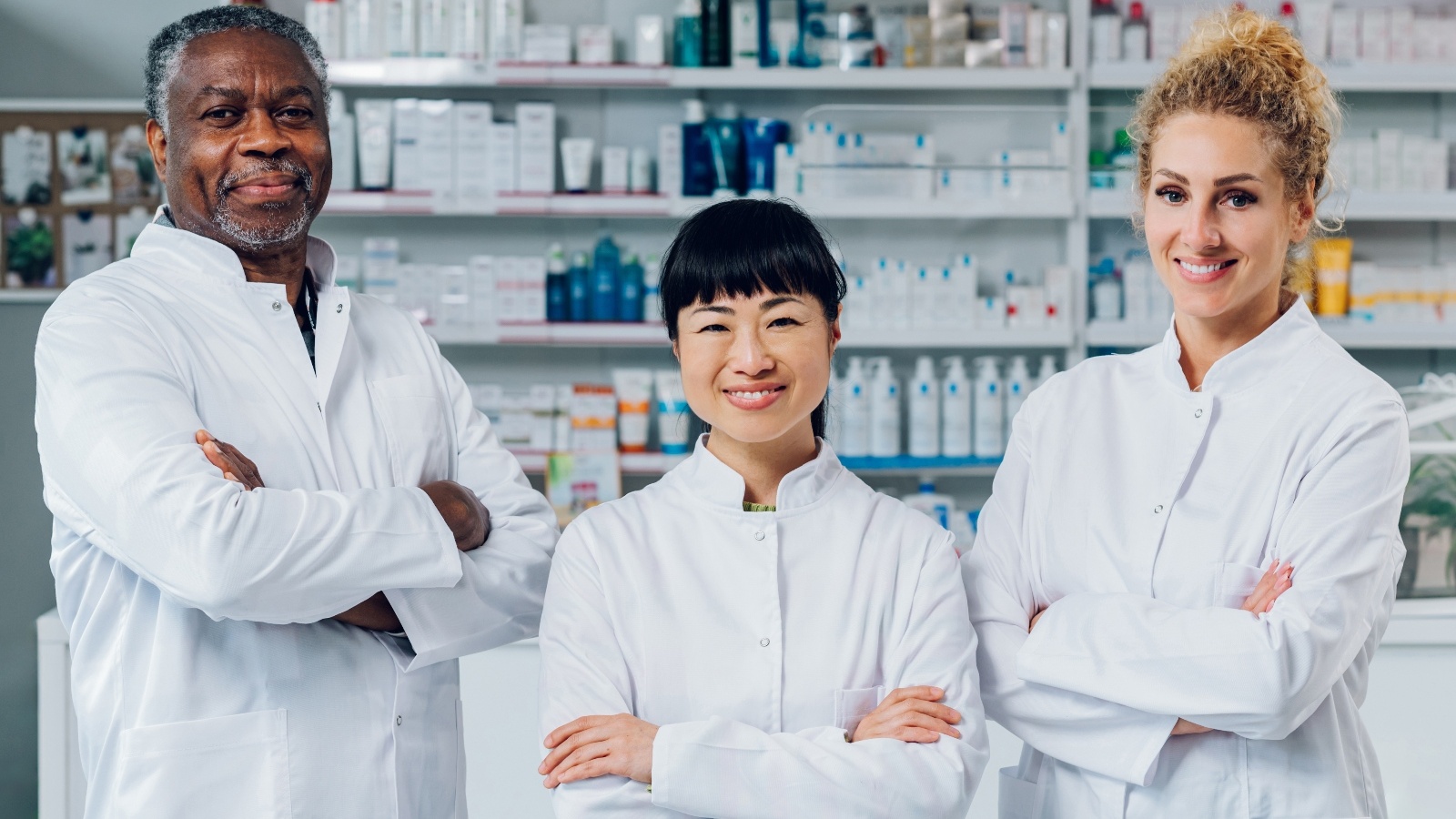 Pharmacy Technicians posing with medications in the background.