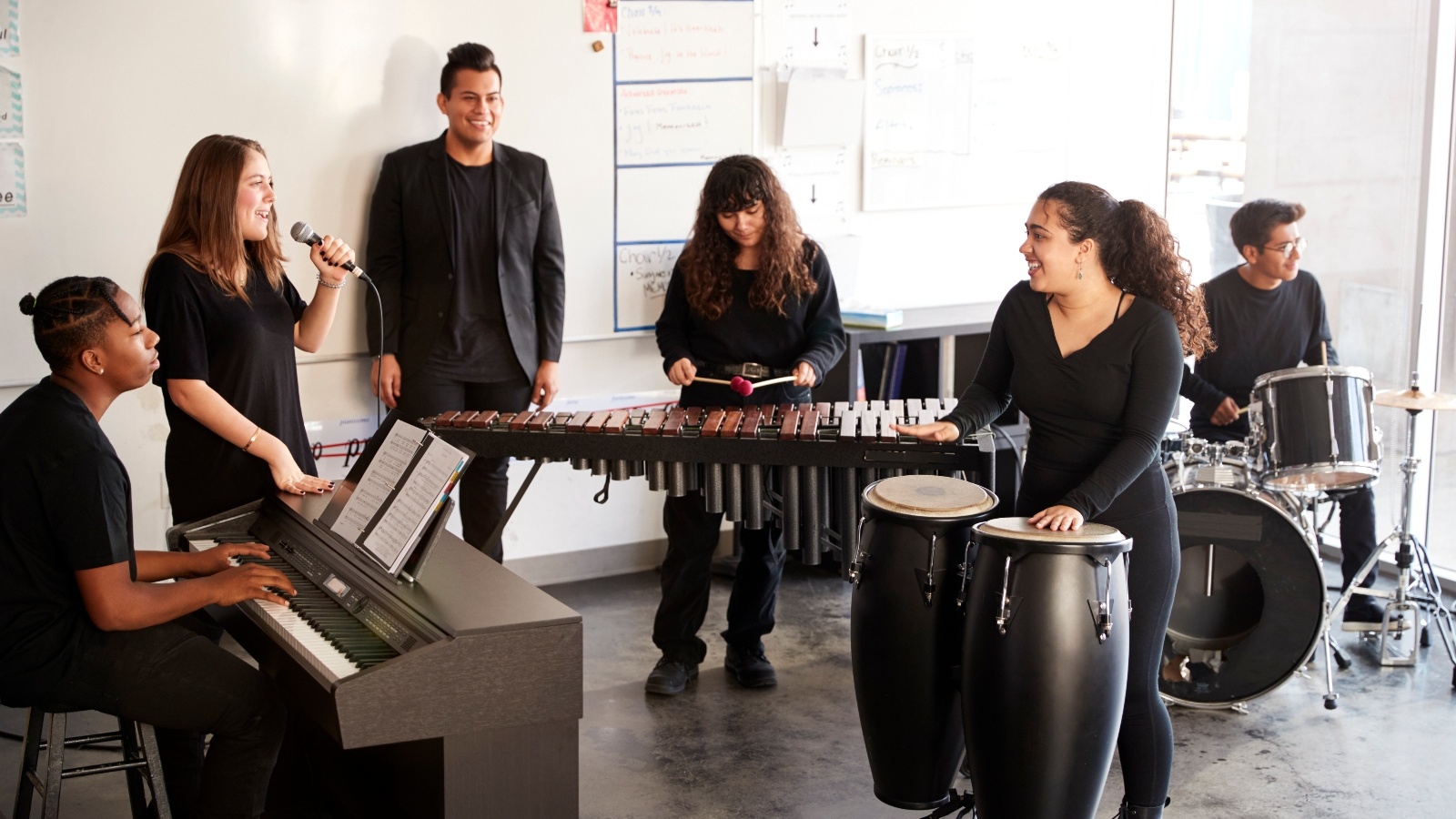 individuals playing different instruments in a classroom setting.
