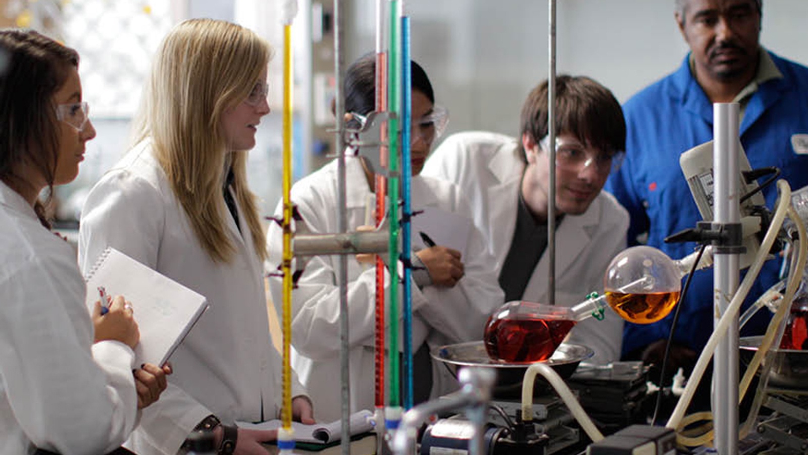 Chemistry students conducting experiments on beakers and test tubes