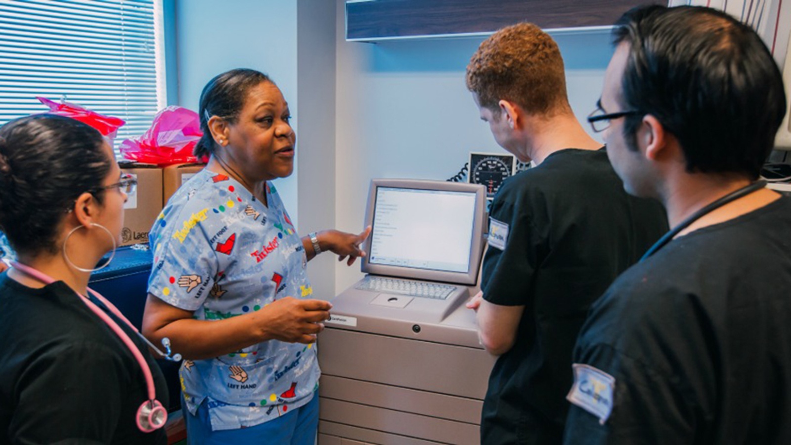 Nursing Instructor showing students how to operate a medical device