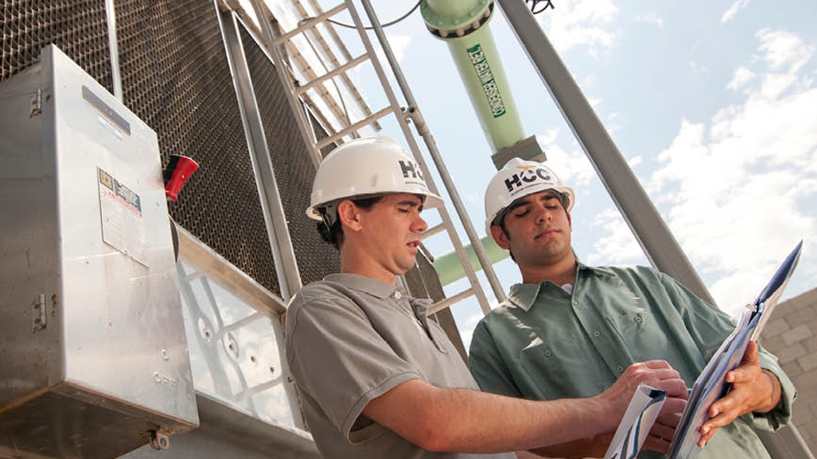 HCC Petroleum Engineering students inspecting a manual on site at a refinery training facility
