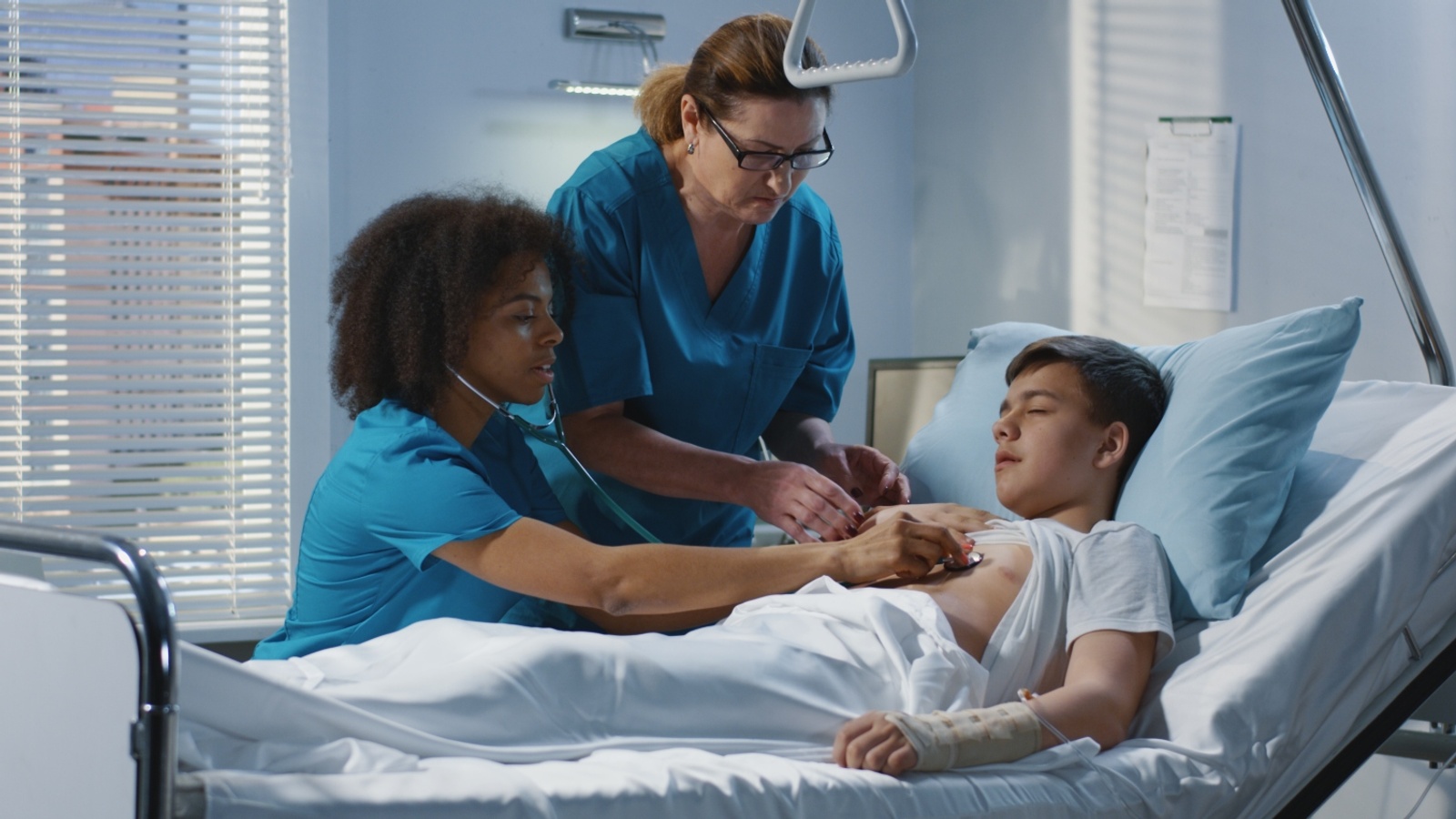 Nursing students checking patients pulse.