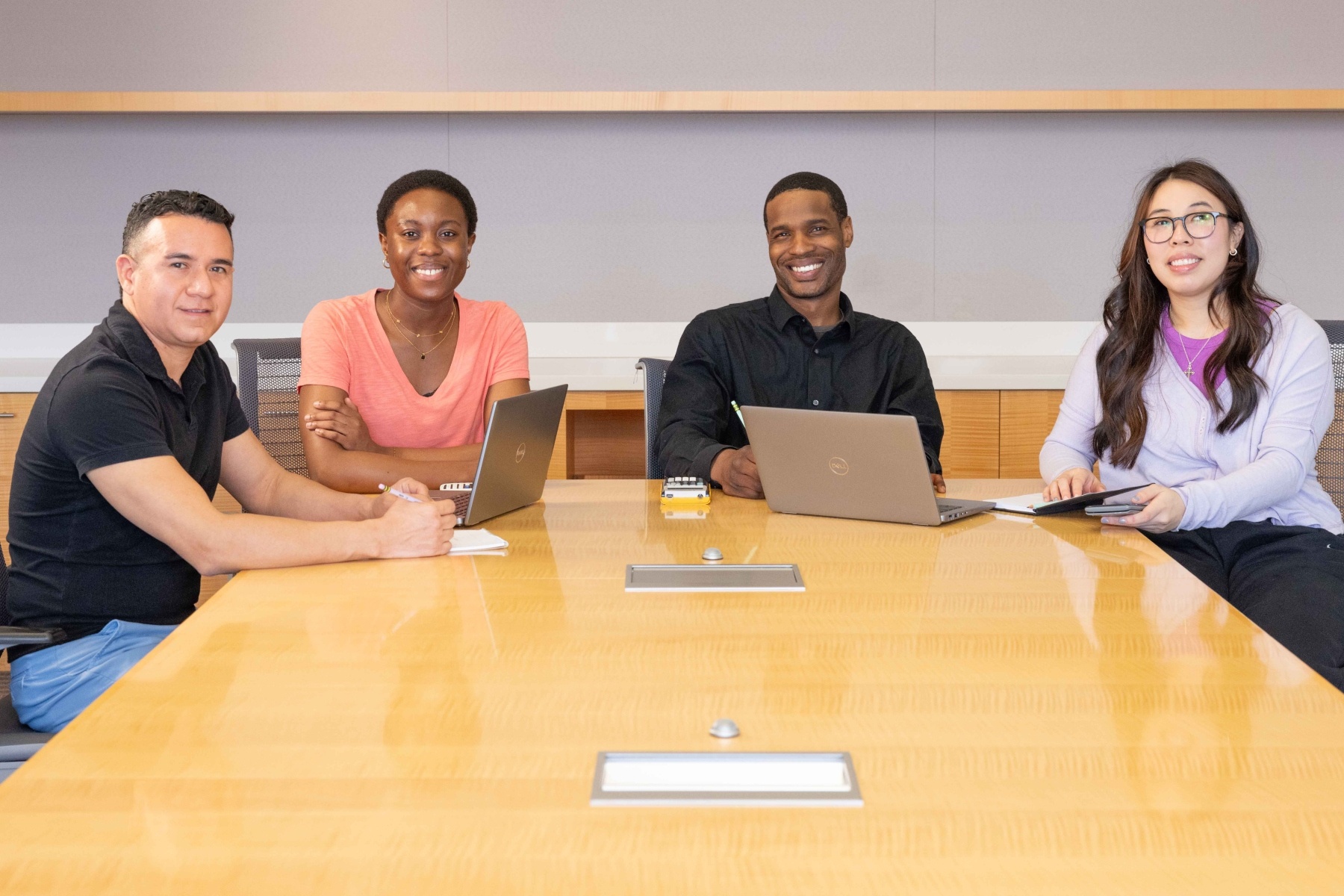 HCC Global Online Students sit at a table and smile.