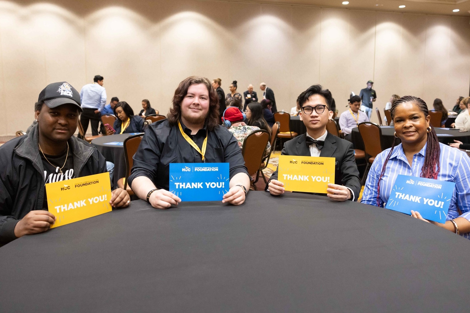HCC Foundation student scholarship recipients holding thank you signs.