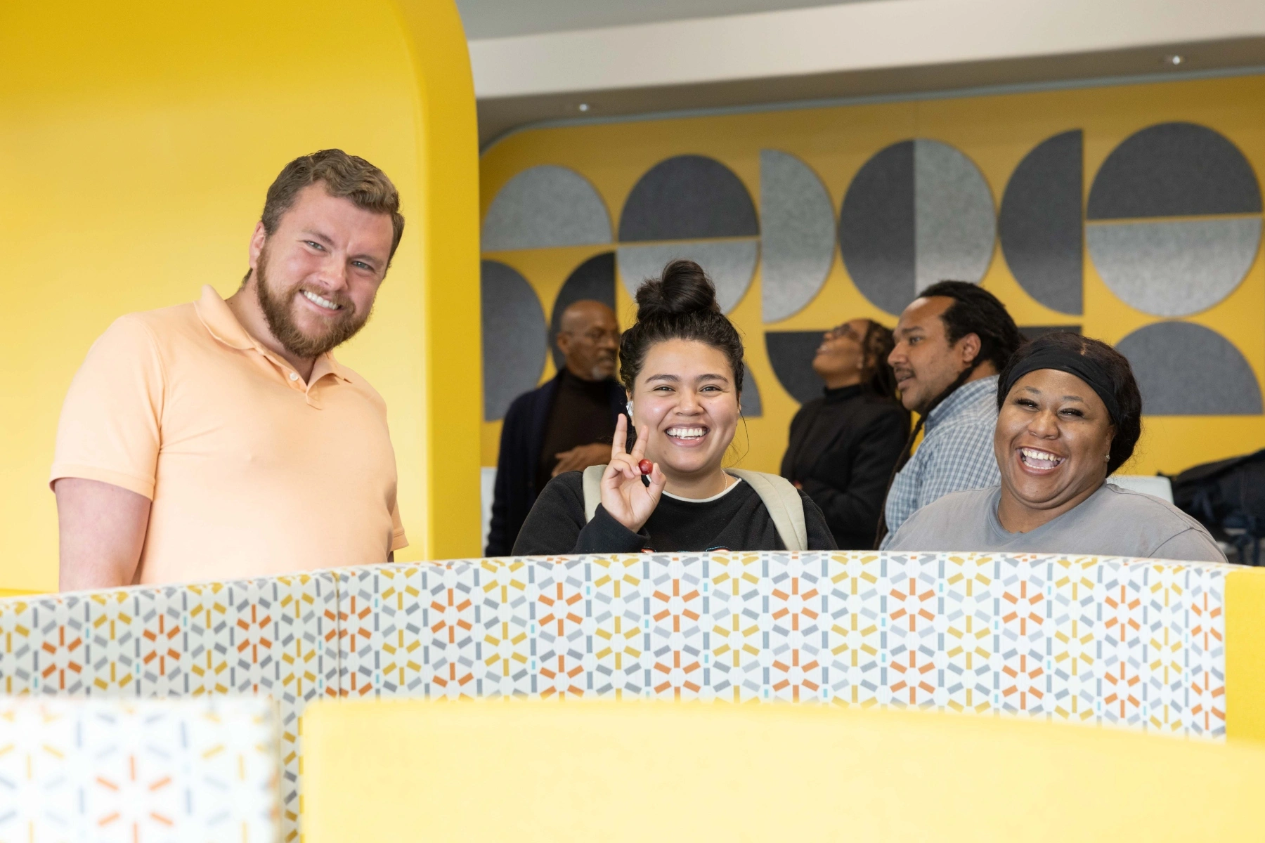A diverse trio of students pose for a photo at an event.