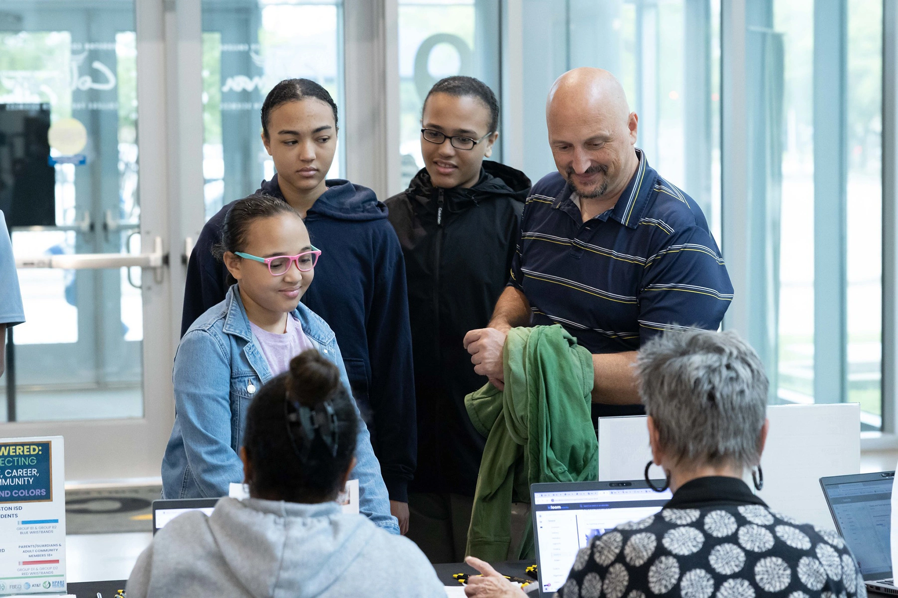 A father and his family asking the help desk on a campus for assistance