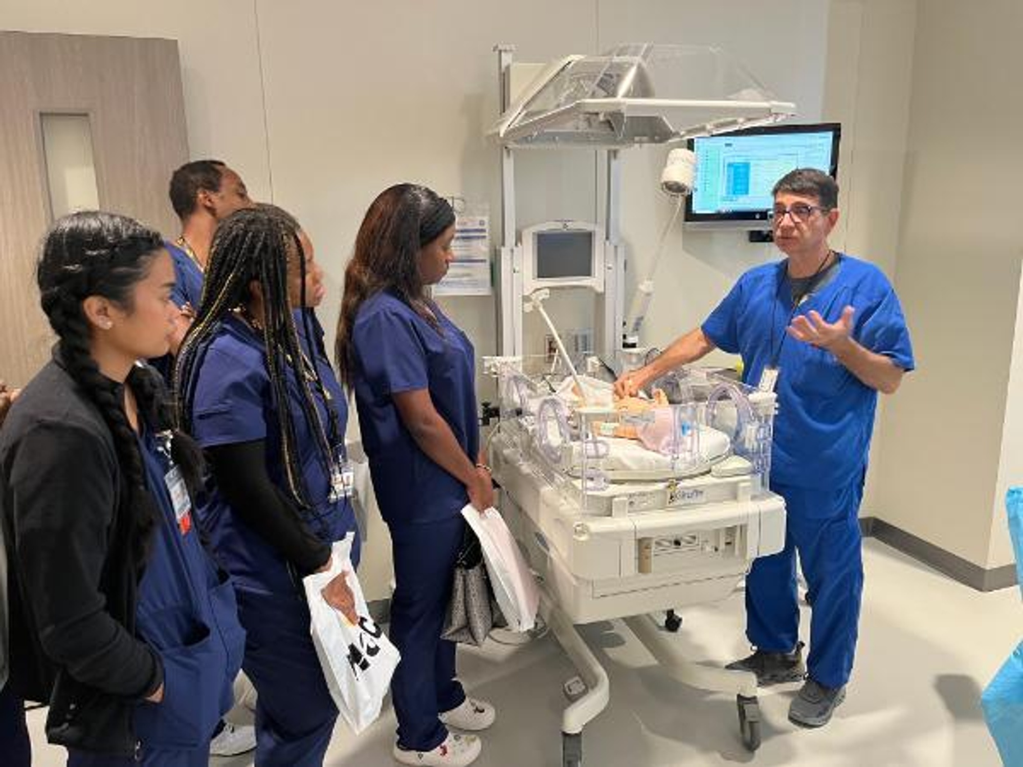 Daniel Guzman Jr., the director of the Health Sciences Simulation Lab, shows students the hands-on Clinical Simulation Lab.