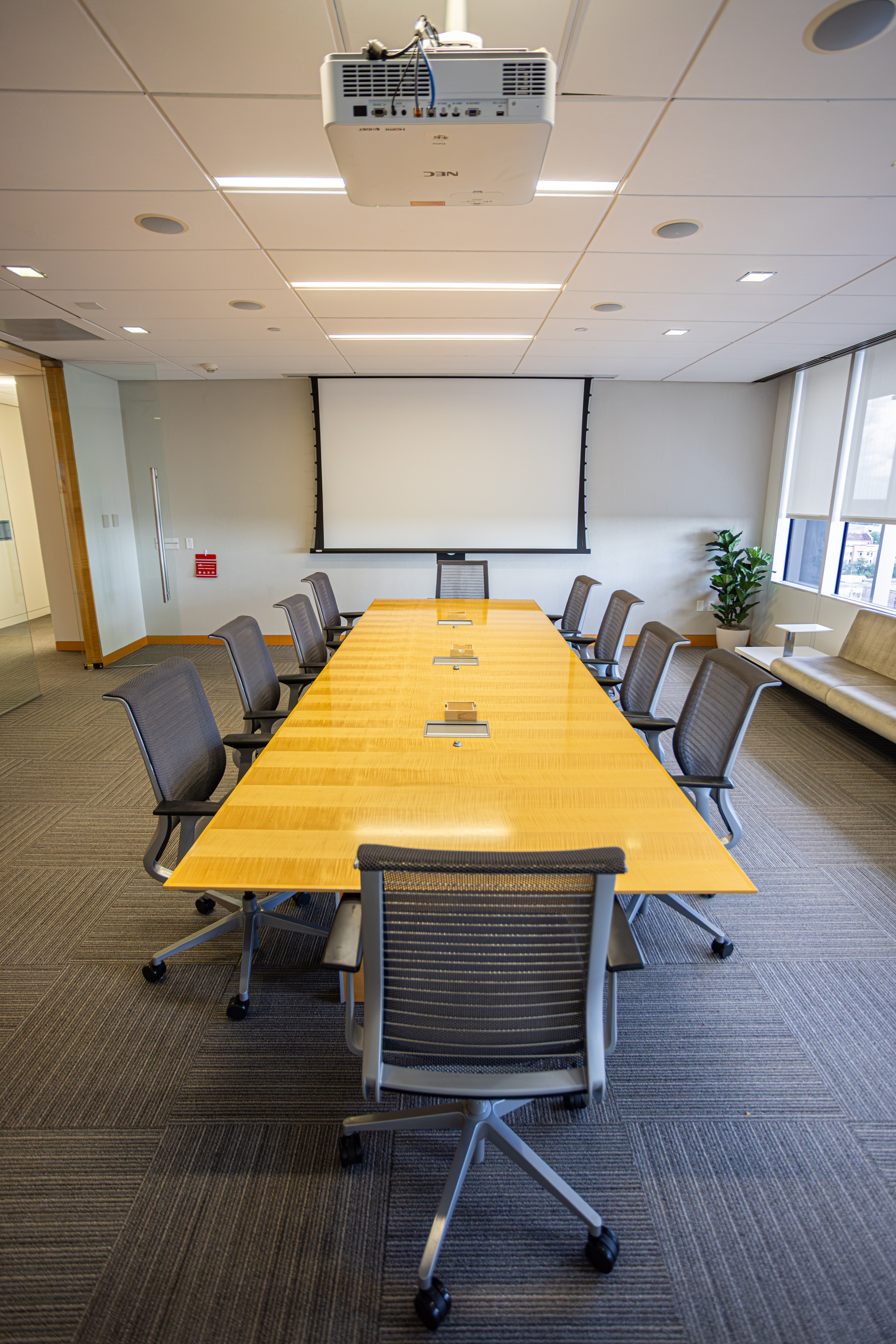 A conference room with a table and multiple chairs.