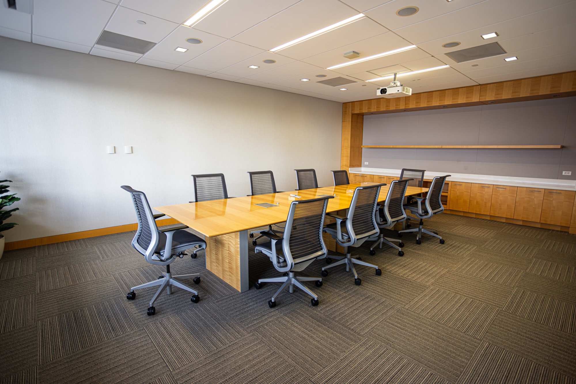 A conference room with a table and multiple chairs.