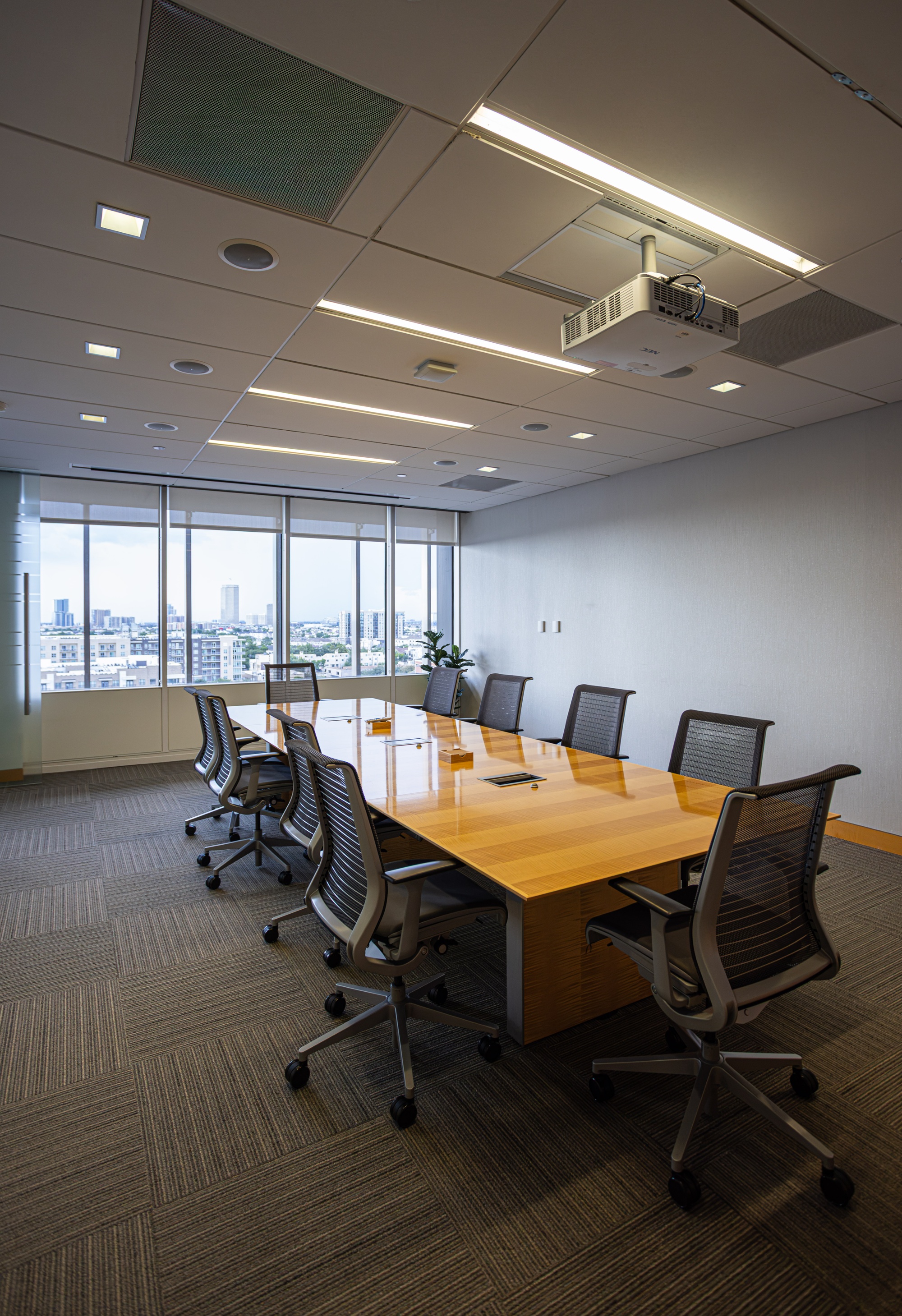 A conference room with a table and multiple chairs.