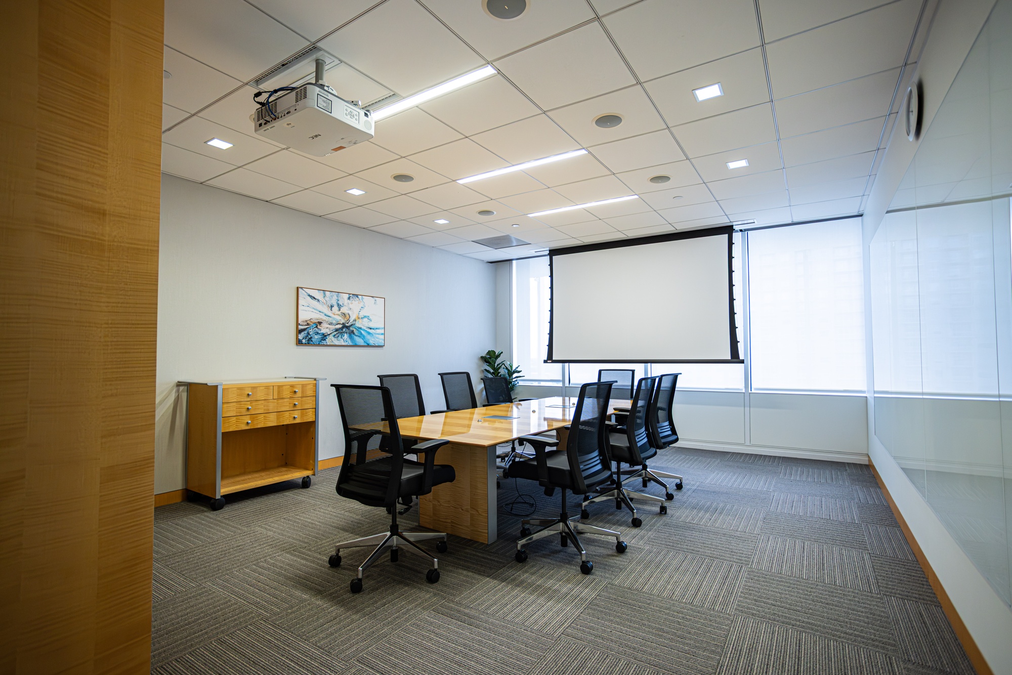 A conference room with a table and multiple chairs.