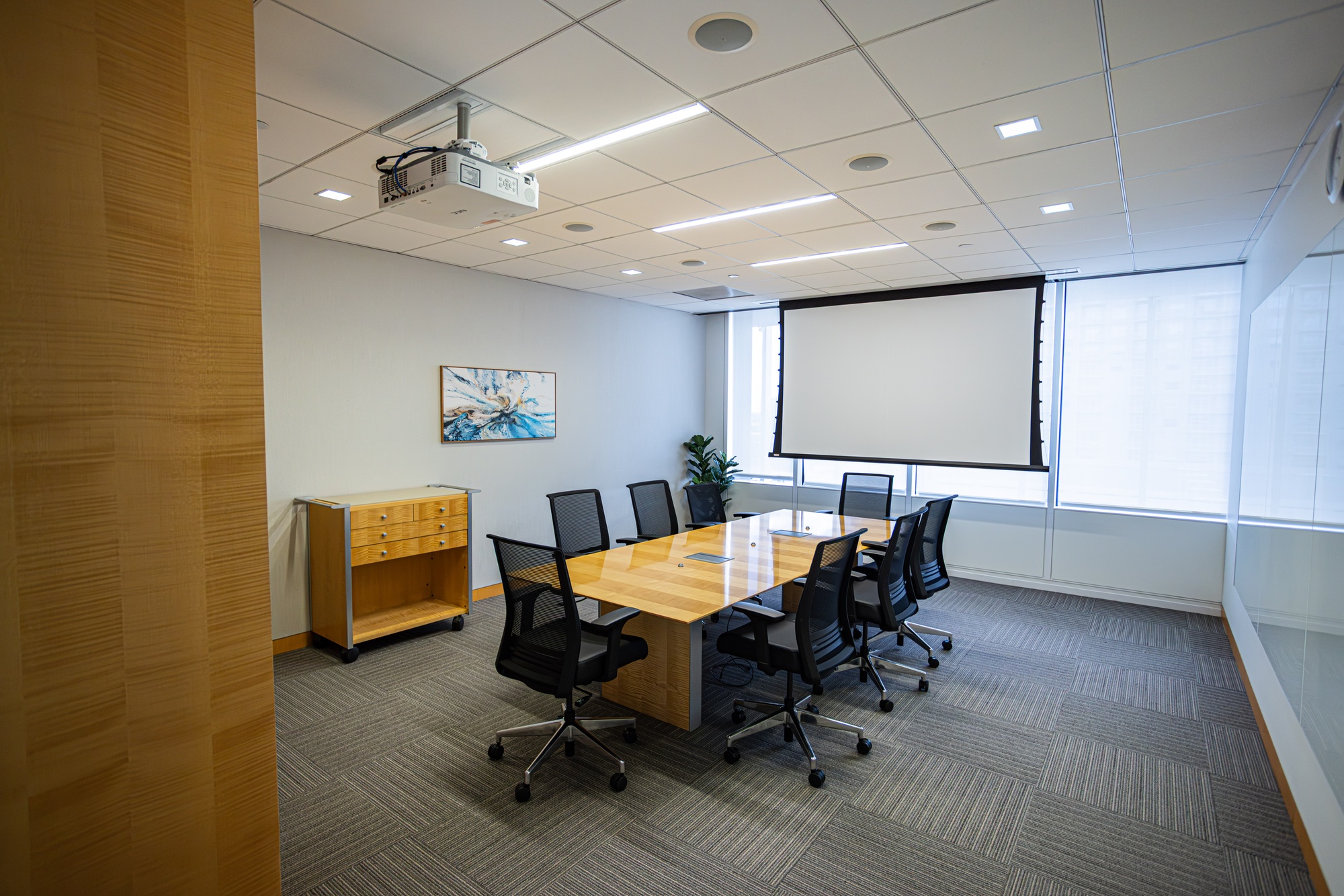 A conference room with a table and multiple chairs.
