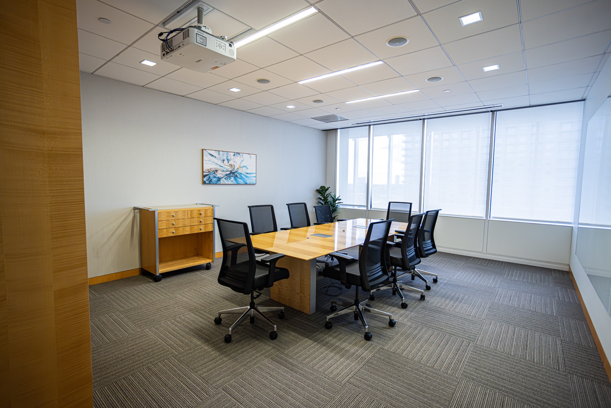 A conference room with a table and multiple chairs.