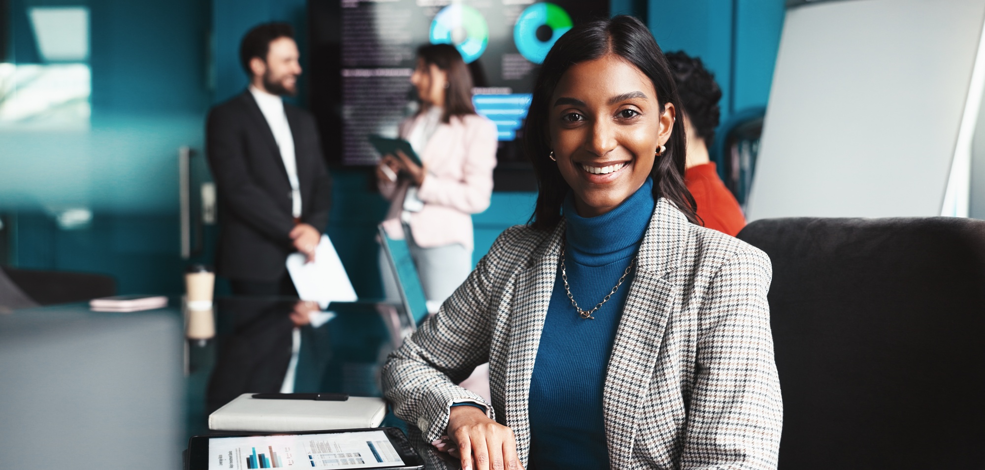 Business woman smiling at her desk full of charts