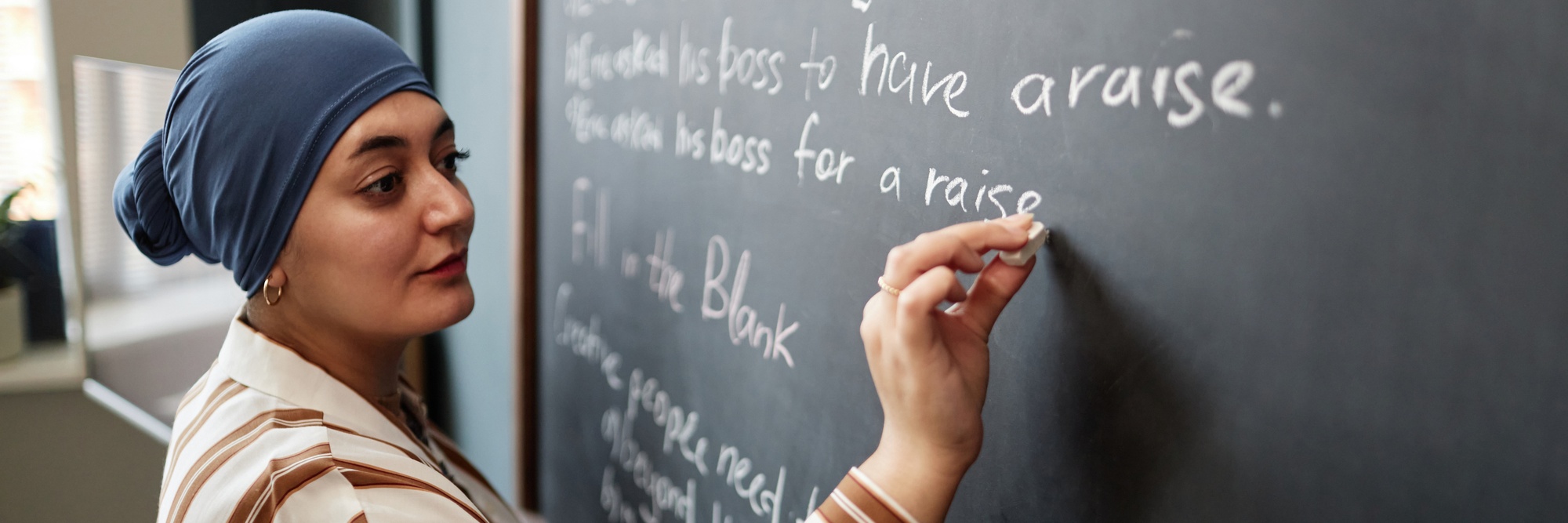 Young lady using a chalk board to learn English