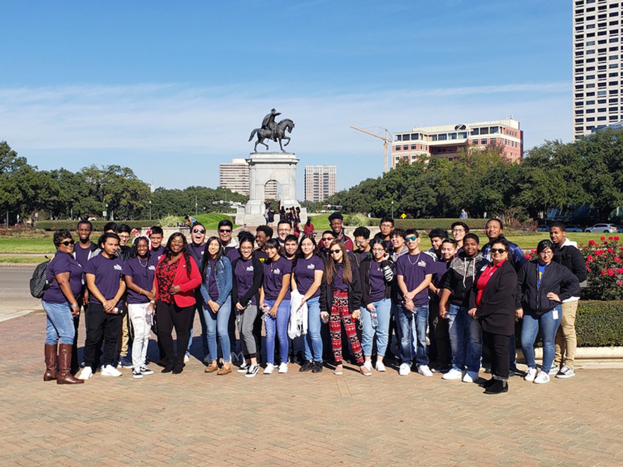 Upward Bound students in front of the Hermann Park statue during a class trip