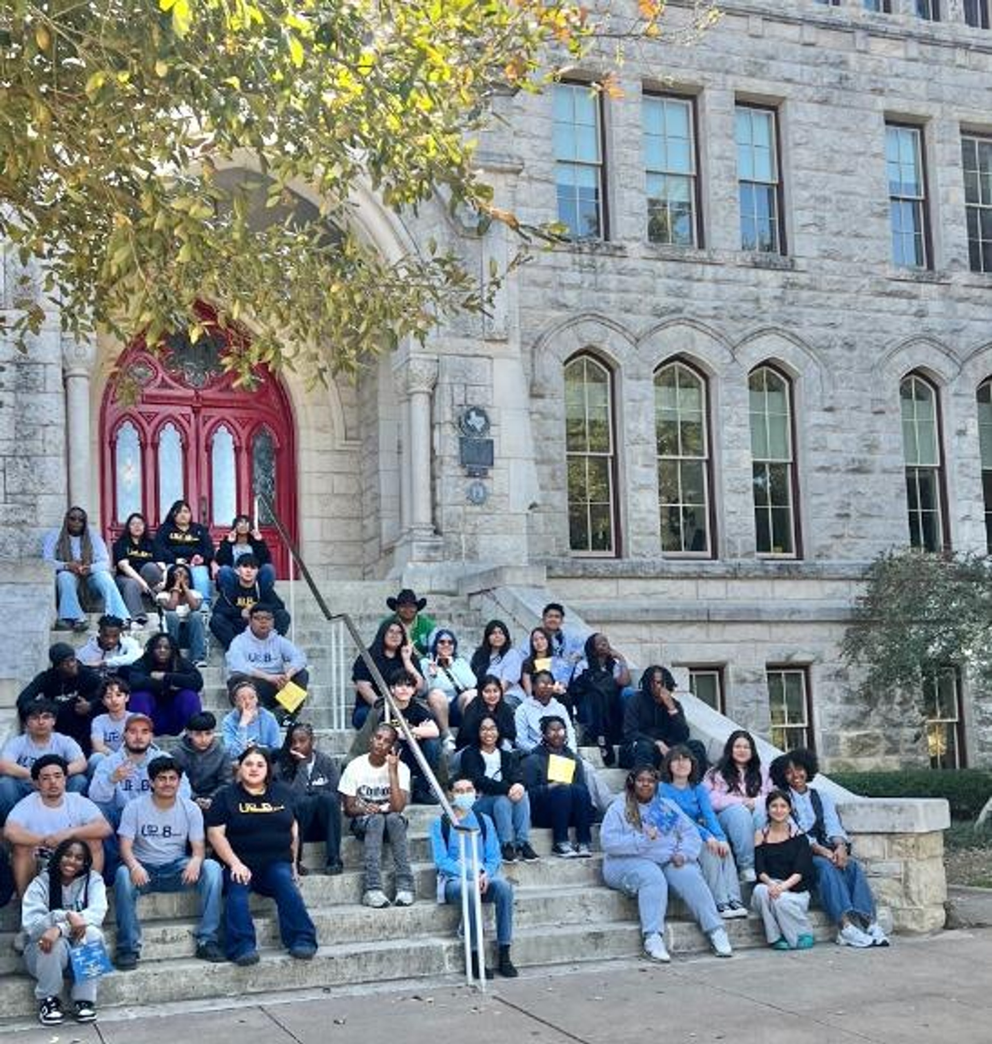 A group photo of students sitting on the steps of a building.