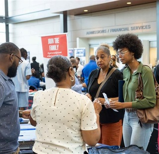 A staff member assisting a mother and student