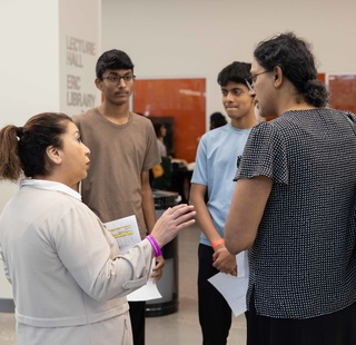 HCC Staff member assisting a parent and student on campus