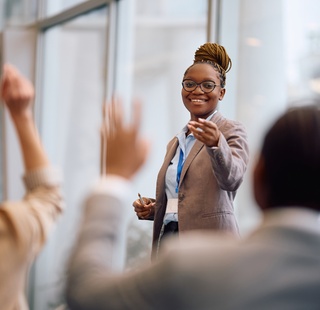 Professionals raising their hands to ask a question during a training session