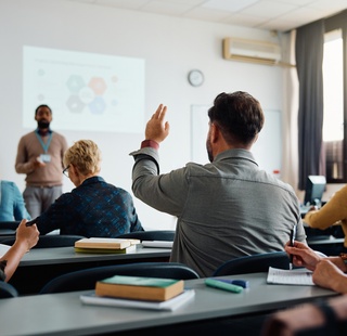 Student raising his hand to ask a question