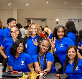 HCC Coleman College for Health Sciences students smile and wave as they pose for a photo.