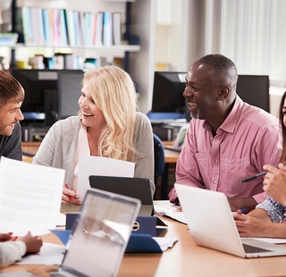 A diverse group of adult students engaged in hands-on training in a modern classroom