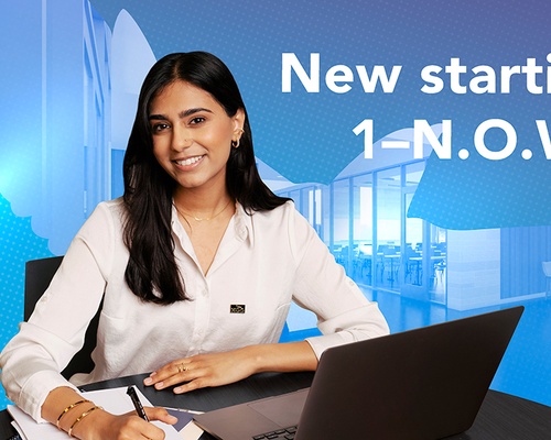 Female student writing notes while using her laptop