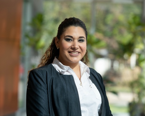 A woman in business attire smiling at the camera