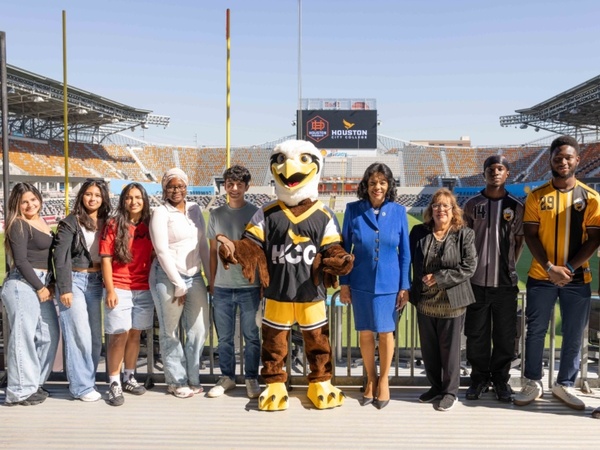 HCC students, the mascot Swoop and HCC officials pose for a photo Shell Energy Stadium.