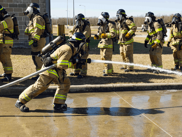 Fire academy students work on a drill using the fire hoses.