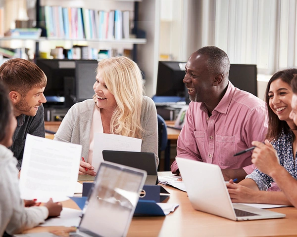 A diverse group of adult students engaged in hands-on training in a modern classroom