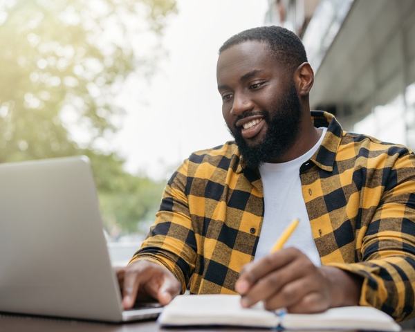 Young male student using his laptop to take classes