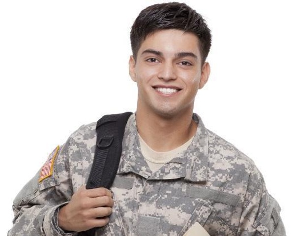 Smiling male student in army fatigues wearing a backpack