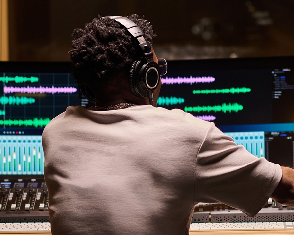 Audio engineer editing music at a mixing console