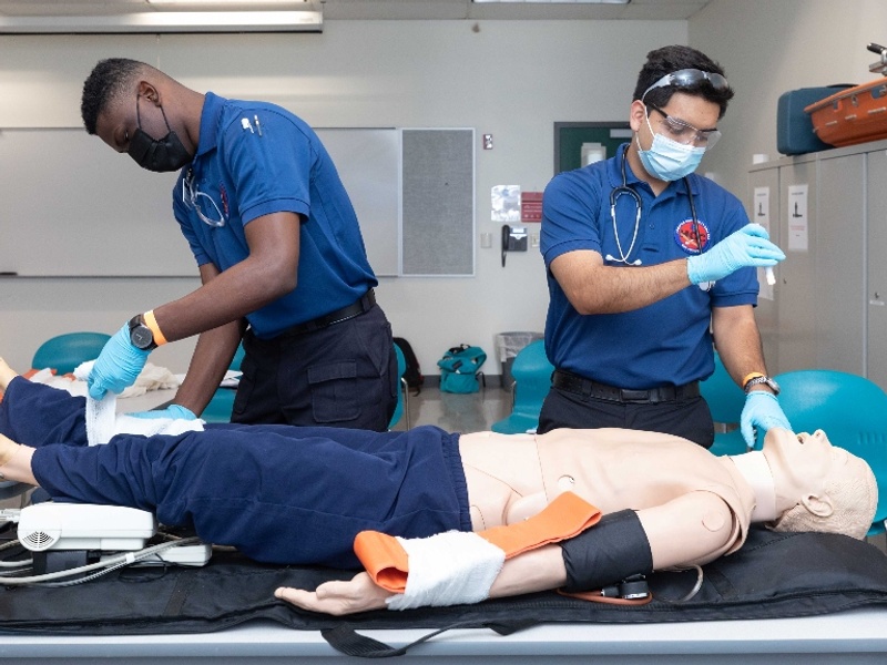 Two HCC Emergency Medical Services students train with training dummy.